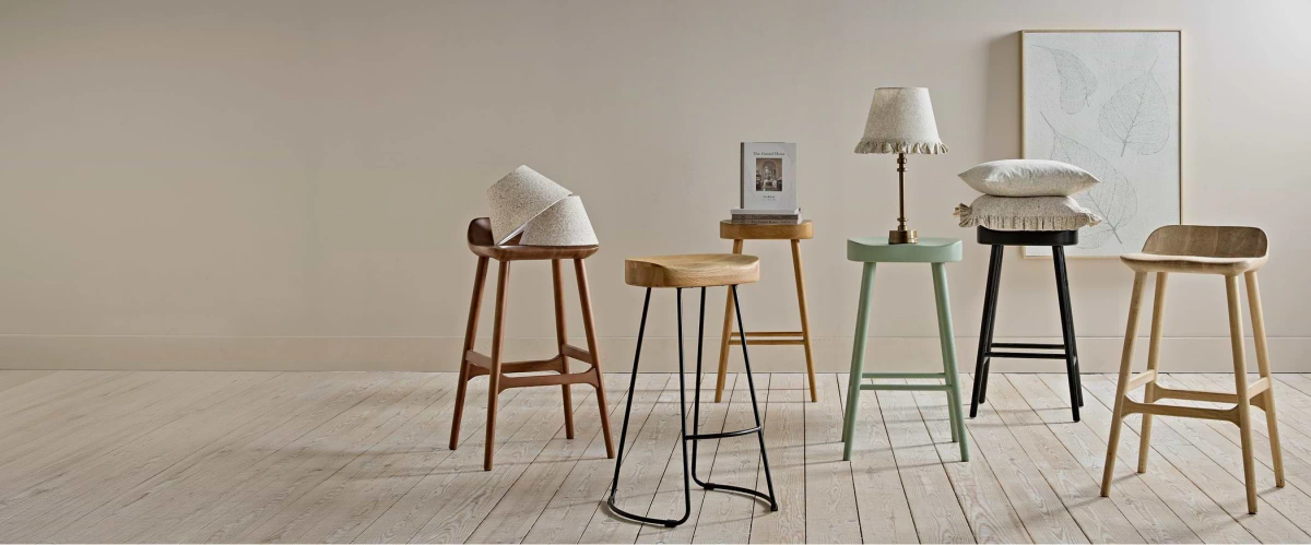 Five counter stools and furnishing details in a composed interior.