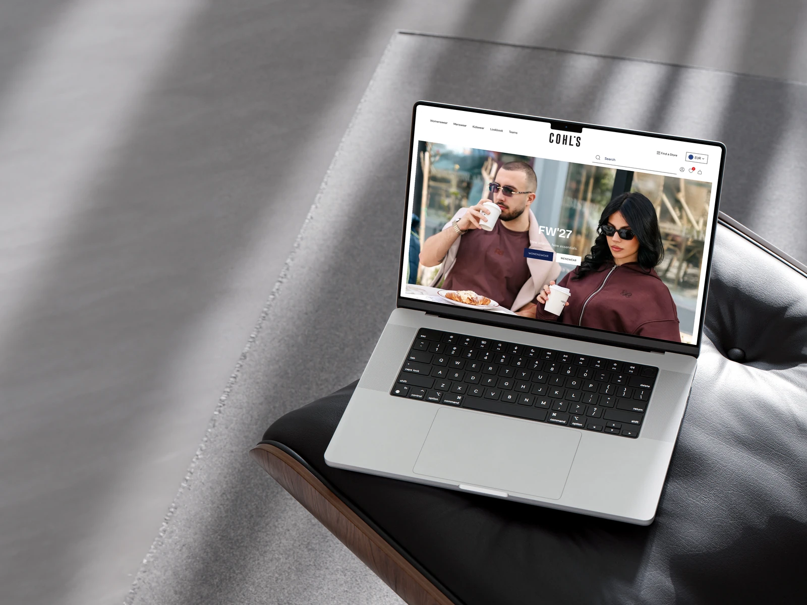 COHL’S fashion store displayed on a MacBook resting on a sculptural leather chair.