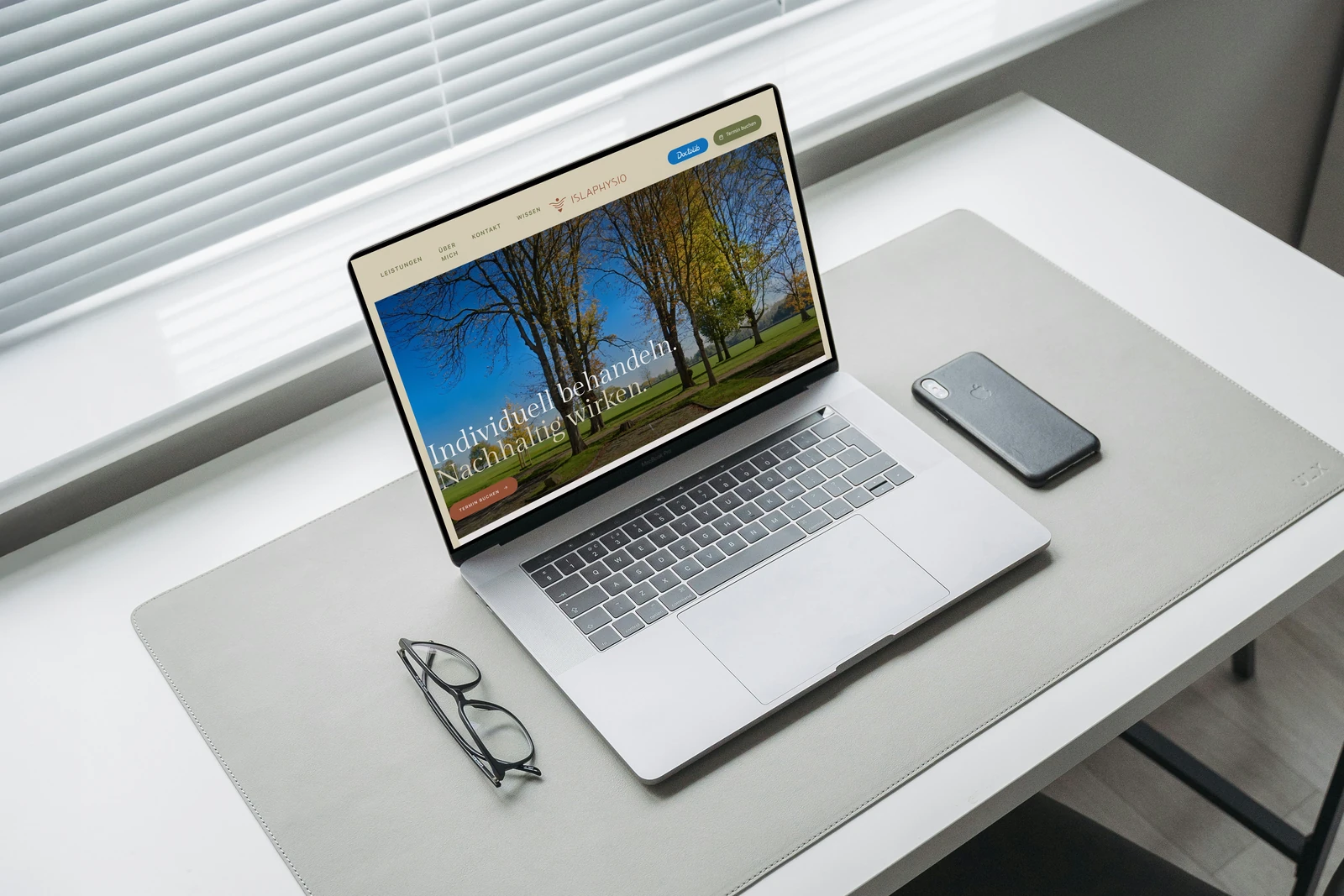 ISLA Physio website displayed on a MacBook in a photographed setting