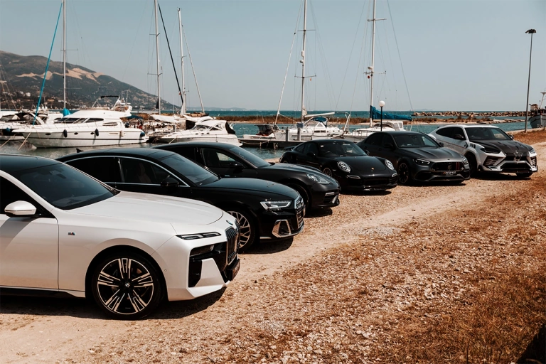 A vehicle line-up beside a marina, photographed on the Top Seven Luxury Cars about page
